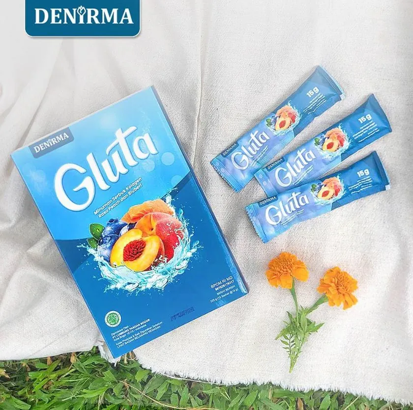 Visual produk DEN’RMA Gluta: kemasan biru, sachet, buah dan bunga di atas kain putih.
